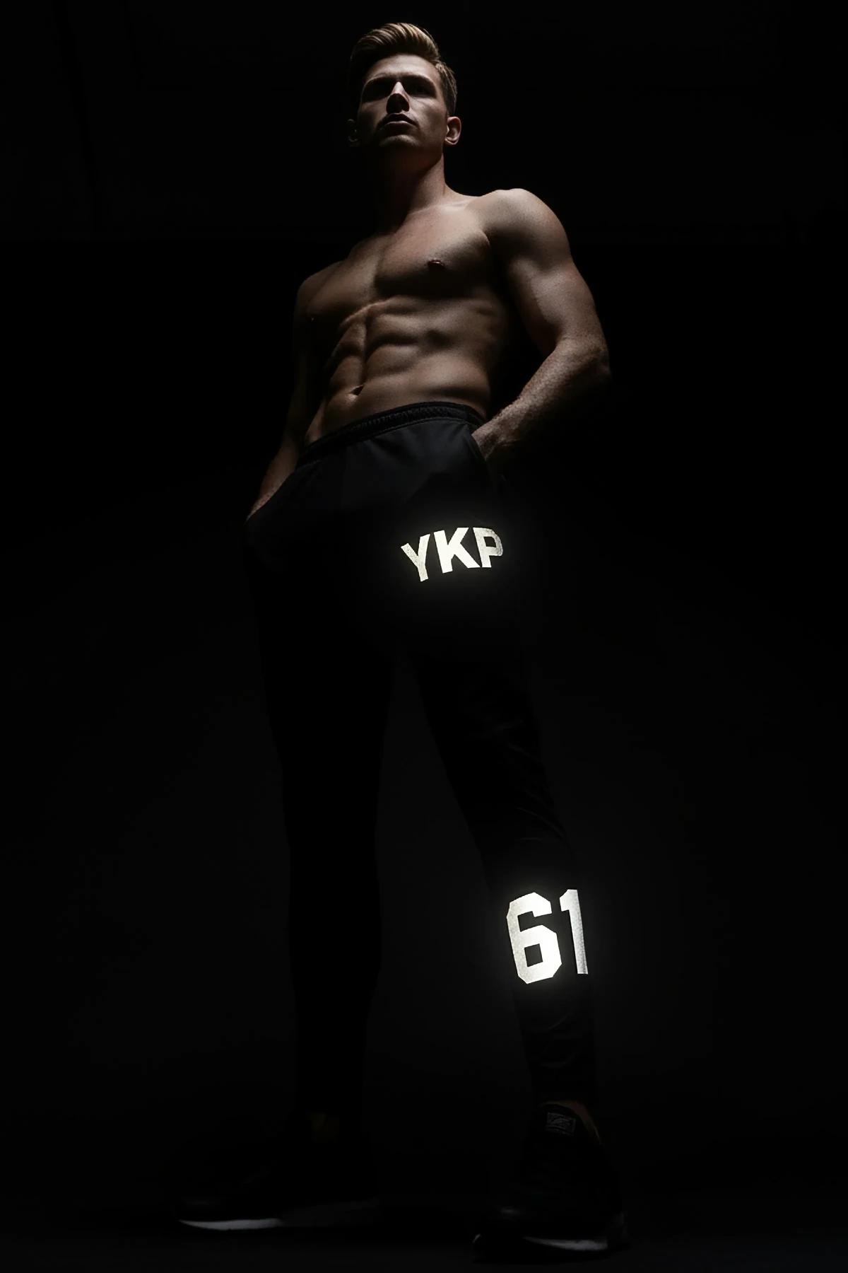 Black Reflective Sport Joggers with MRT Logo and 98 Graphic Worn by Man