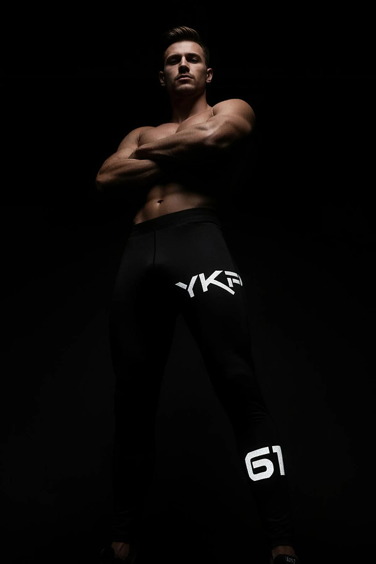 Black Reflective Sport Joggers with MRT Logo and 98 Graphic Worn by Man