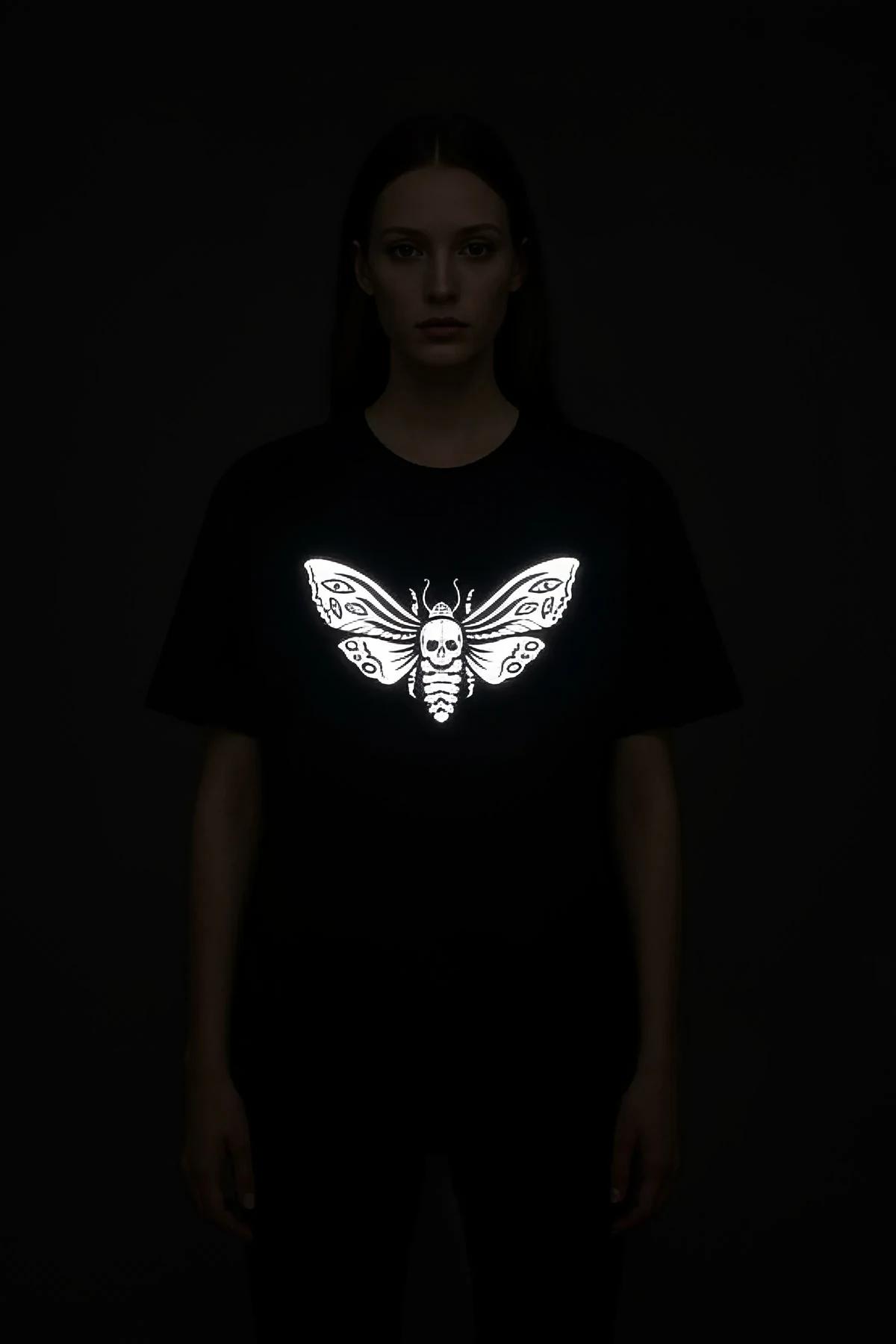 Black cotton blend t-shirt with a striking white reflective skull moth graphic on the chest.