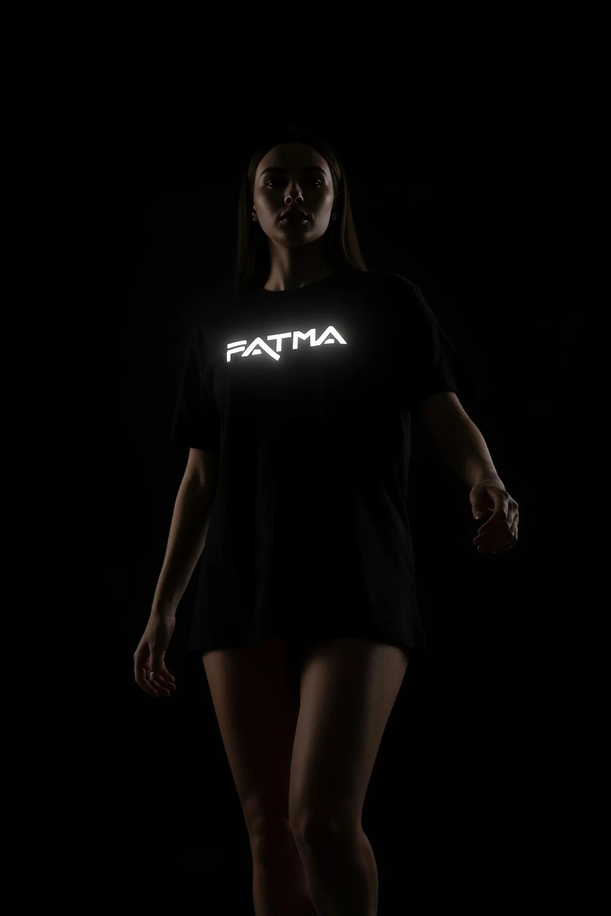 Reflective graphic top in black worn by