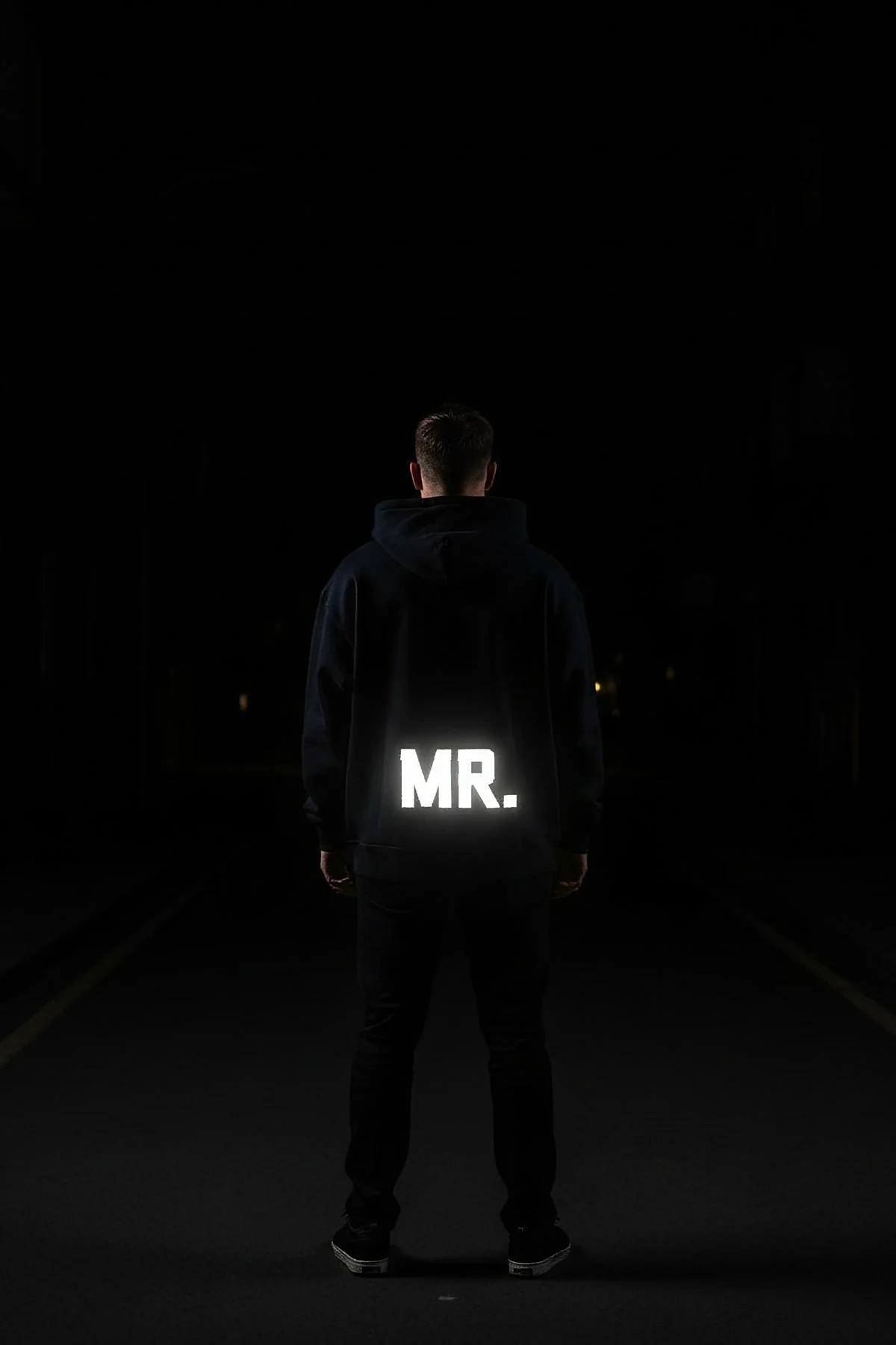 Reflective navy blue hoodie with glowing MR. print on back in dark setting