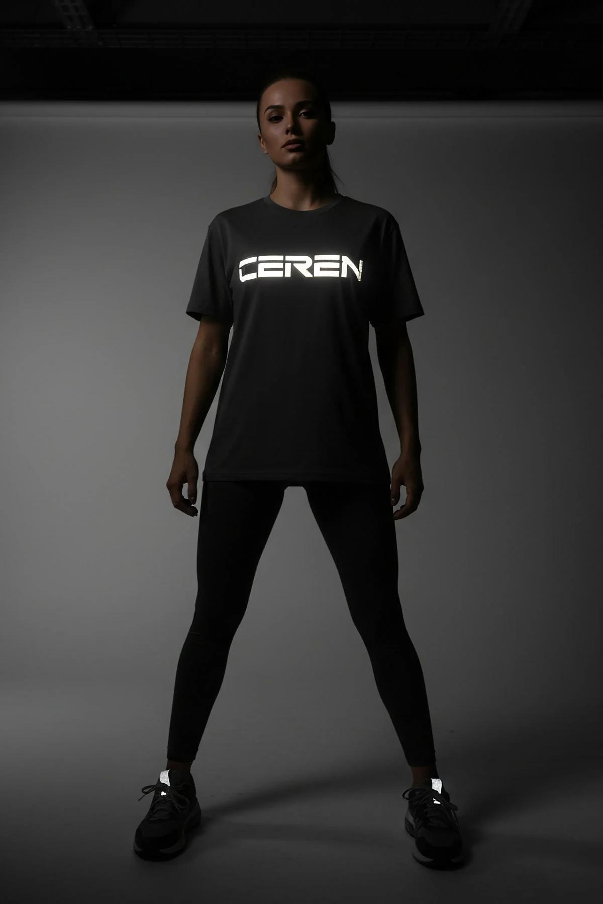 Black t-shirt with "Buğçu Yeditepe Dance Club" reflective graphic in the center, worn by a woman sitting.