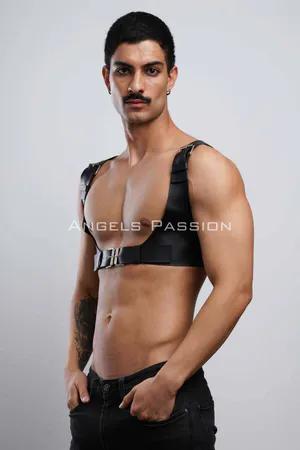 Black faux leather chest harness with silver buckle and adjustable straps on male model