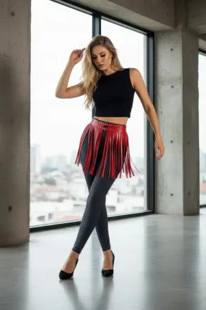 Kırmızı suni deri kısa etek modeli, bel kısmında metal toka ve bol hareketli püsküller ile kombinlenmiş