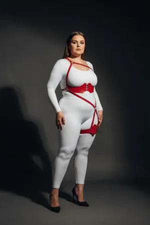 Red vegan leather strappy body harness with O-ring leg detail worn by a model