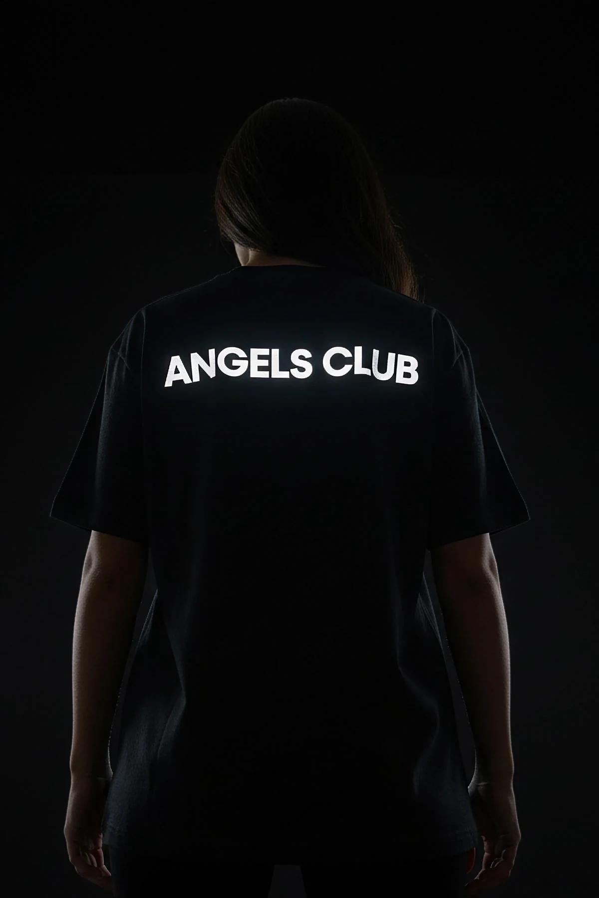 men black oversized tee reflective print activated under flash showing bright silver Angels Club graphic