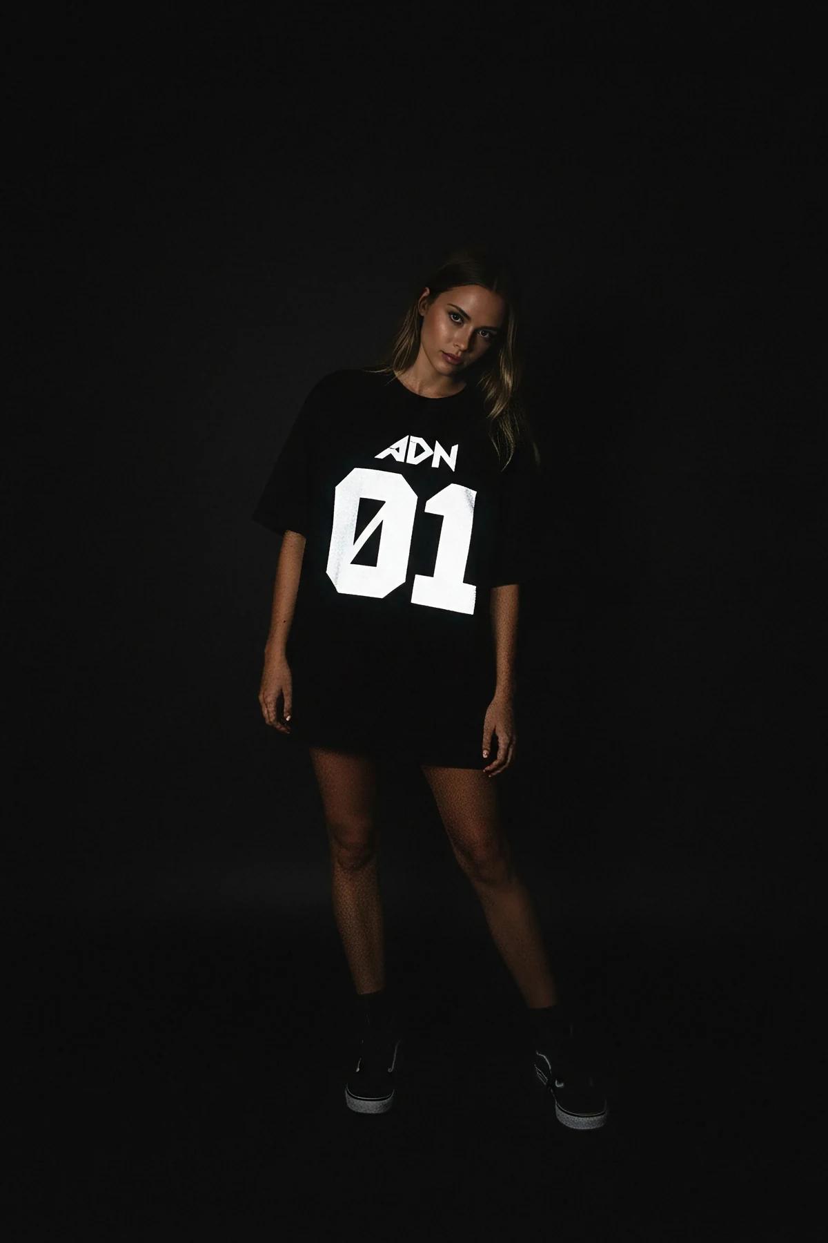 front view black oversized t-shirt with large reflective graffiti chest print in daylight