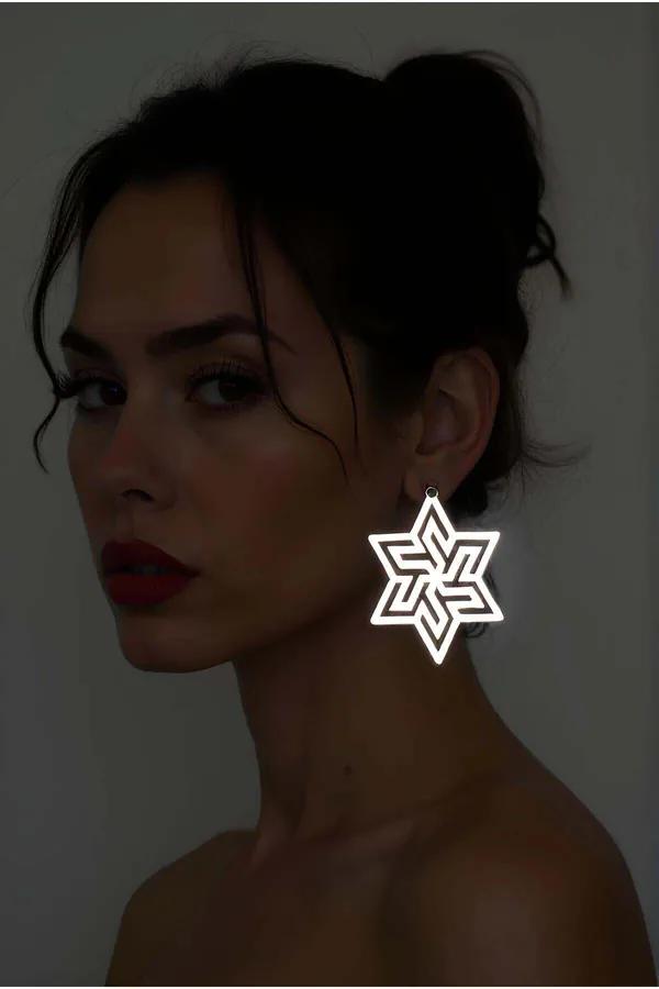 Beyaz reflektörlü lazer kesim soyut yıldız küpe karanlık ortamda parlak geometrik desen