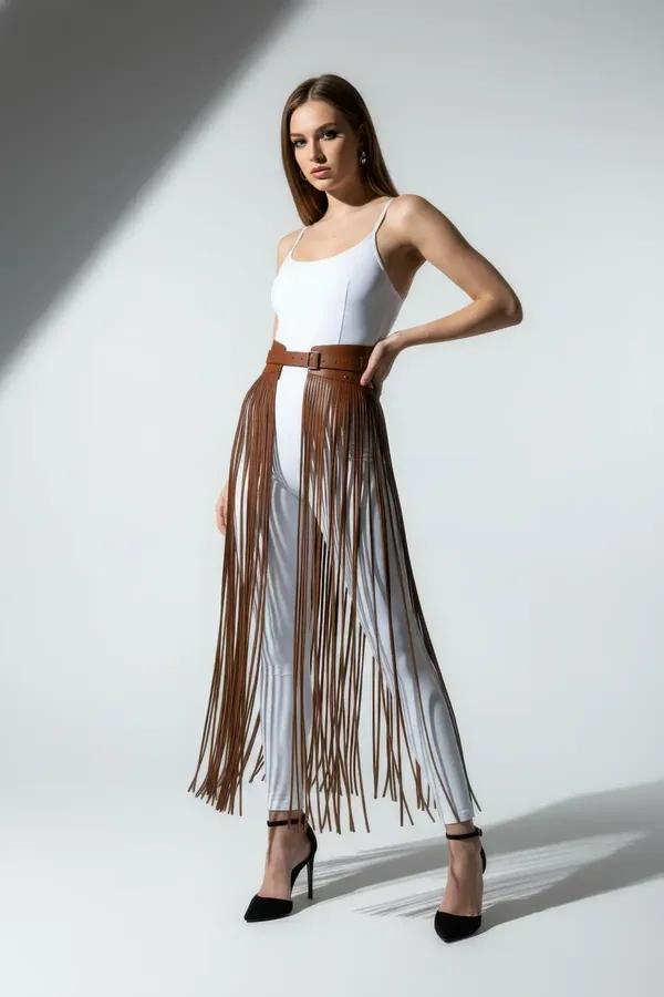 Brown faux leather waist belt with long fringe overlay strands reaching midi length, adjustable pin-buckle, worn over white t
