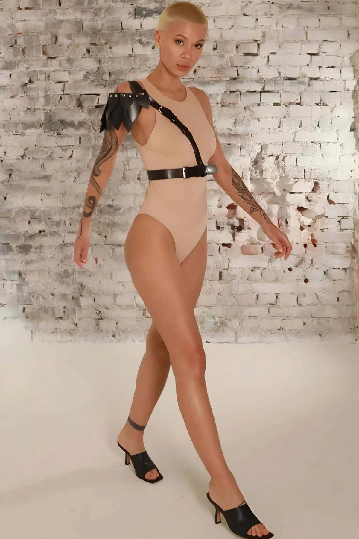Yaprak detaylı siyah deri harness kemer, sade krem rengi bodysuit üzerinde kombinleme önerisi