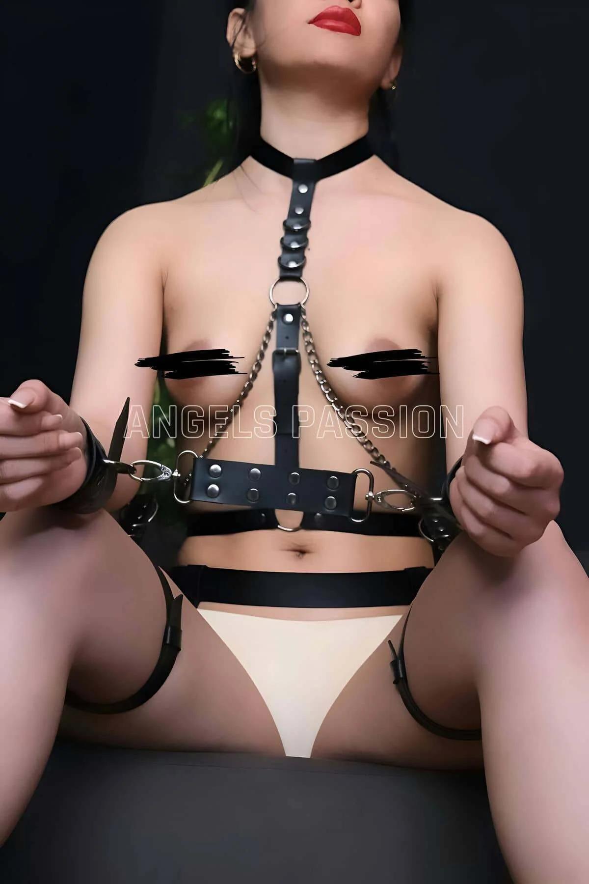 Back view of black faux leather body harness showing collar and waist band adjustment buckles