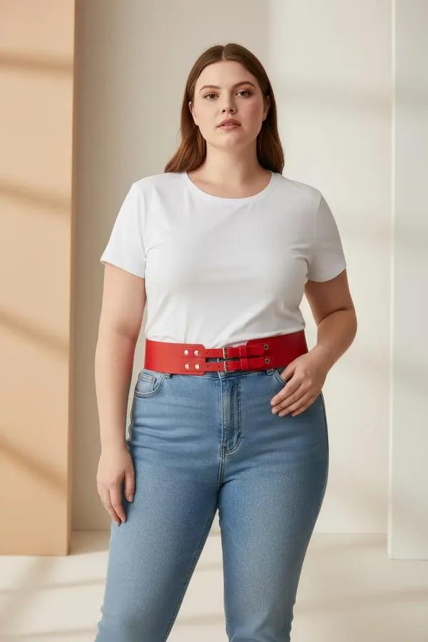red faux leather wide waist belt with twin silver buckles worn over cream top and beige trousers