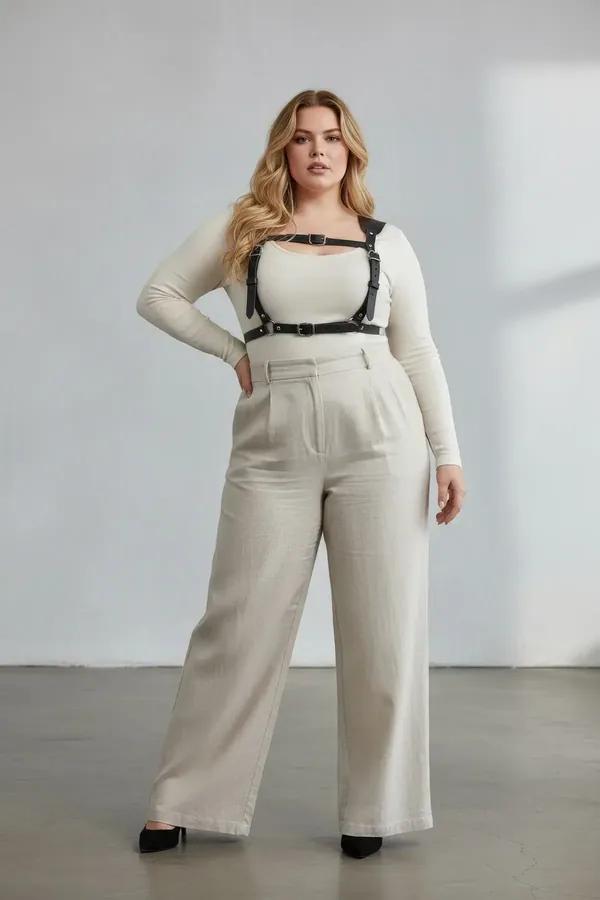 black faux leather caged chest harness with four silver-tone buckles worn over cream ribbed tank top plus-size model