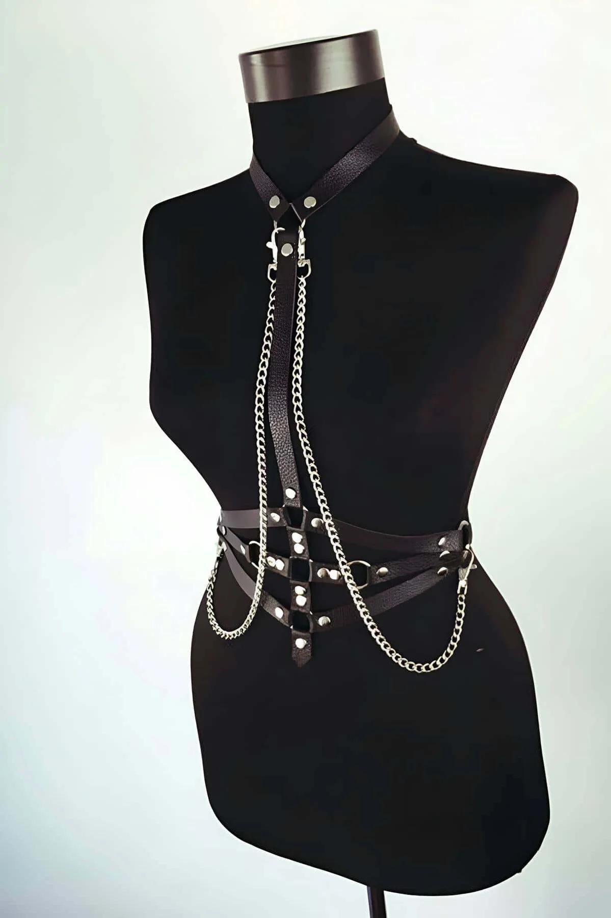 black faux leather body harness with silver curb chains draped from neck collar to waist belt with rivet studs