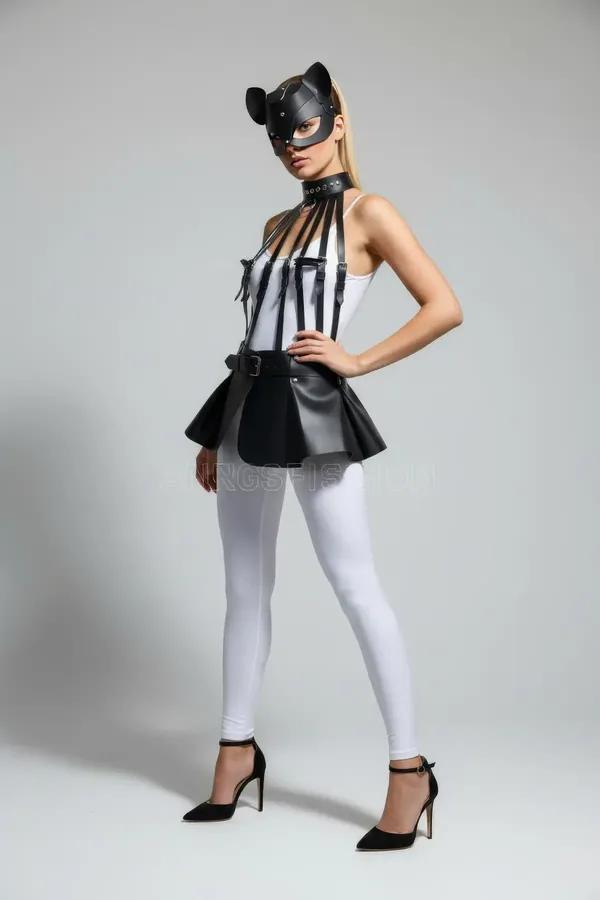 black faux leather peplum harness with vertical chest straps and structured waist belt worn over white bodysuit