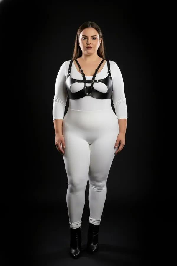 black faux leather harness bra with silver O-ring buckle and oval cut-out chest panel on plus-size model