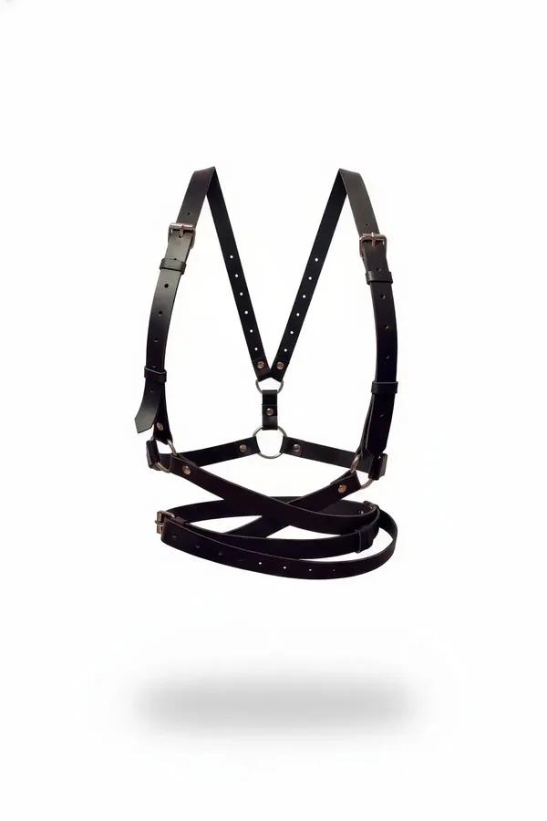 Black faux leather full body harness with criss-cross waist straps, silver O-rings, and adjustable rectangular buckles on whi