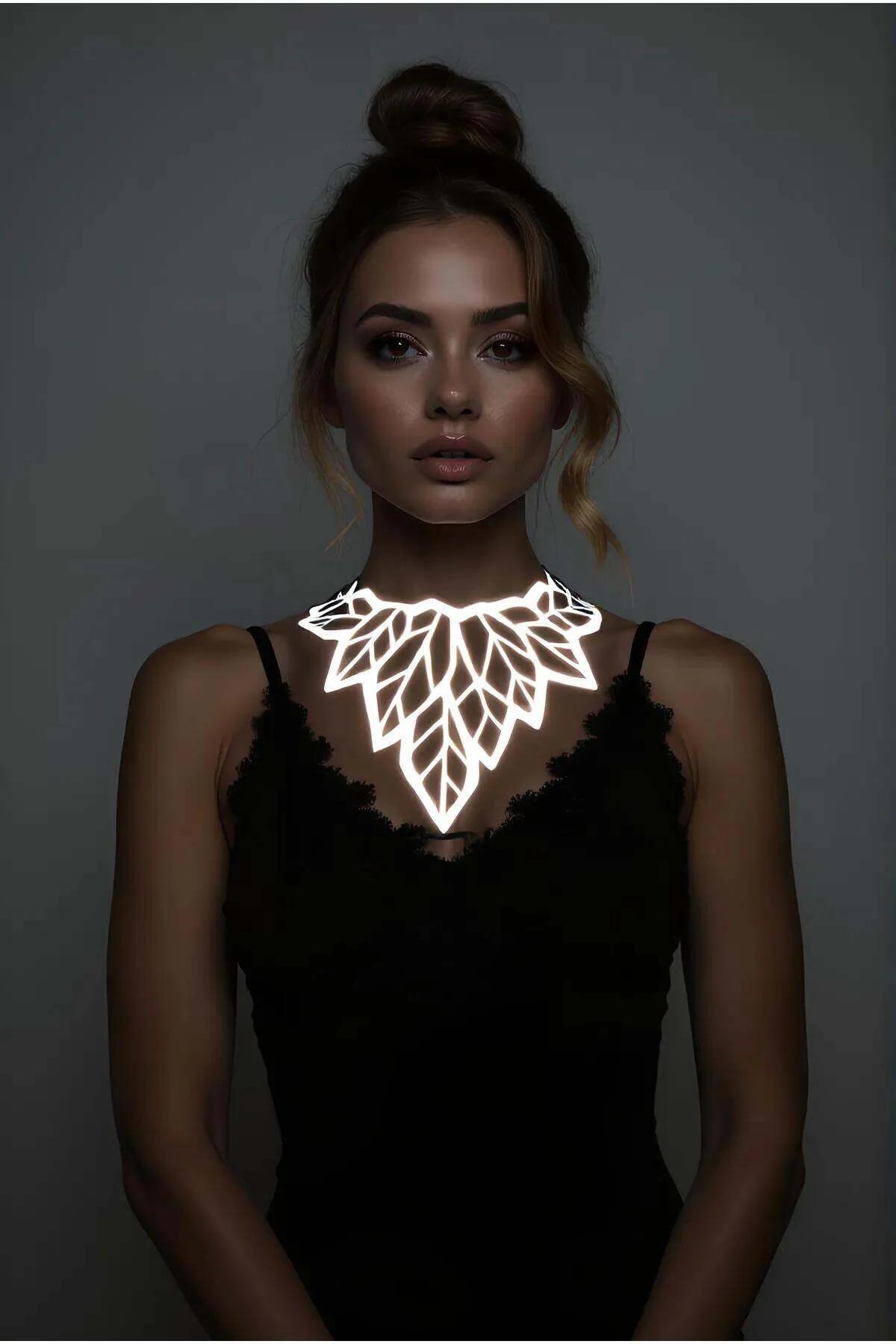 Reflective leaf choker necklace silver laser-cut panel glowing white on black lace cami in low light