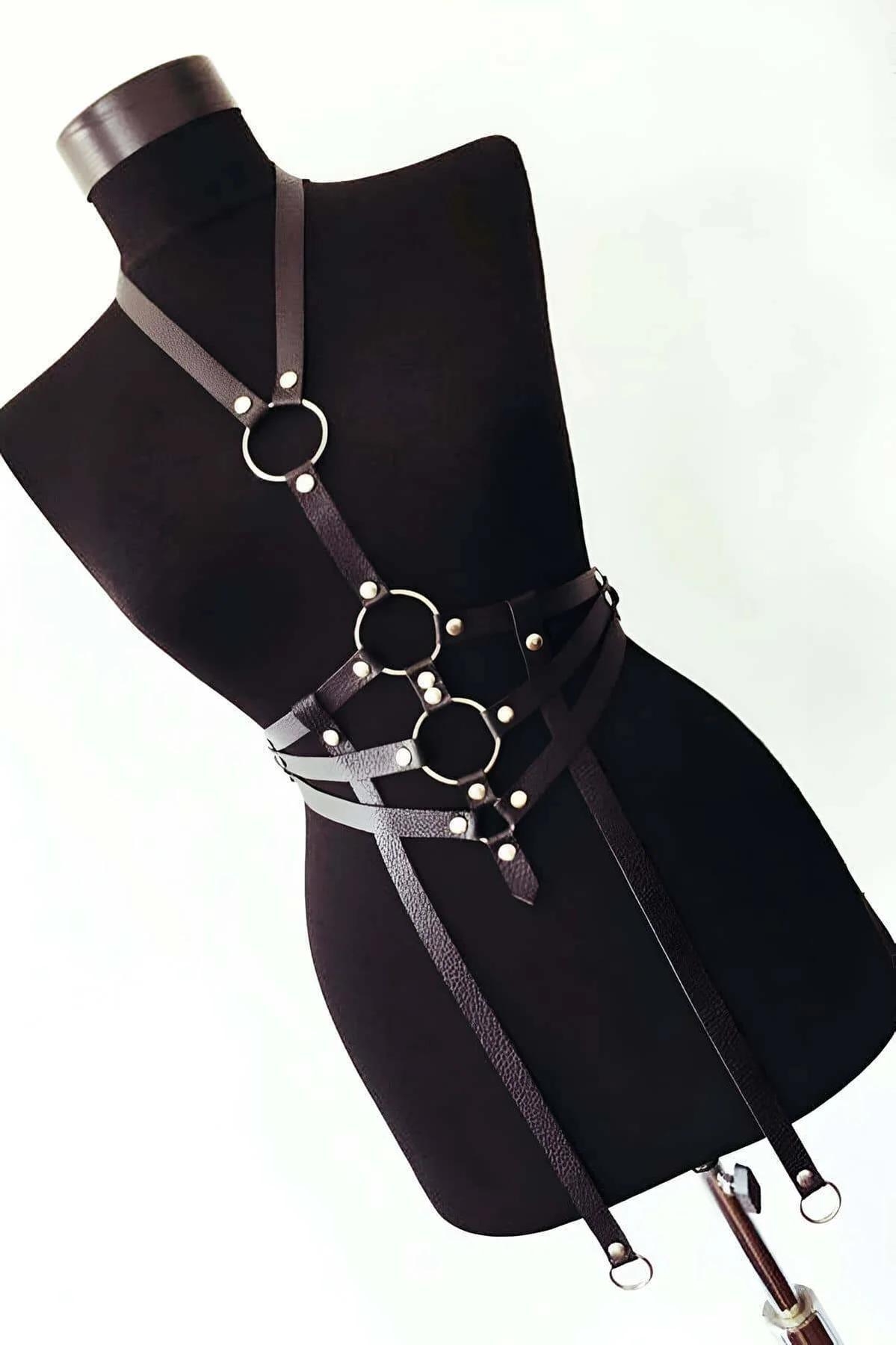 Front view of black vegan leather chest harness showing triple O-ring stack and silver stud rivets