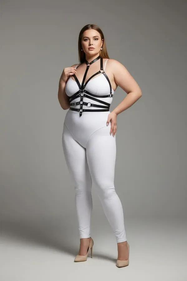 black faux leather body harness with silver O-rings and multi-strap torso cage worn over white bodysuit