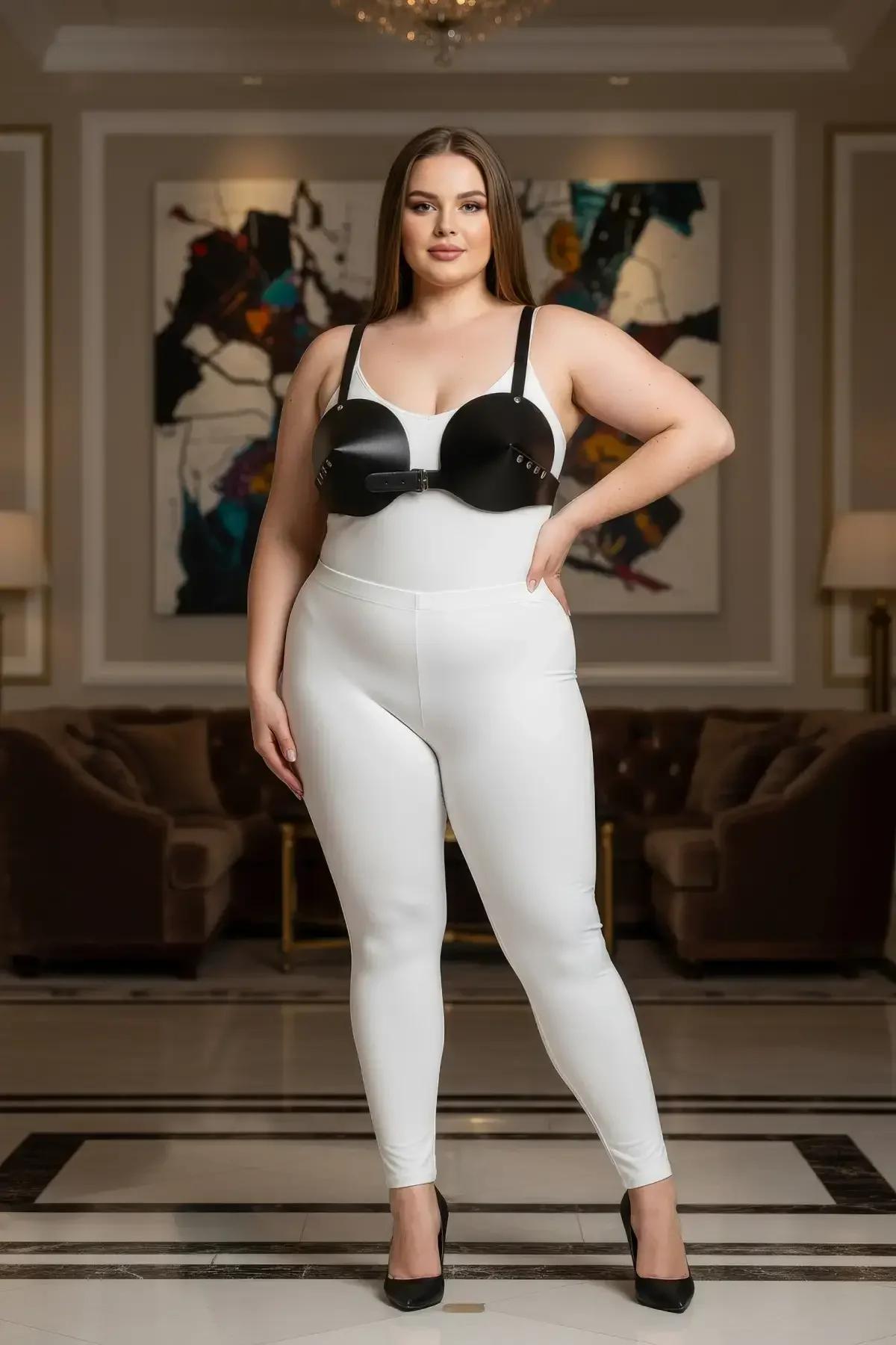 structured black faux leather chest harness bra layered over white fitted bodysuit full-length view