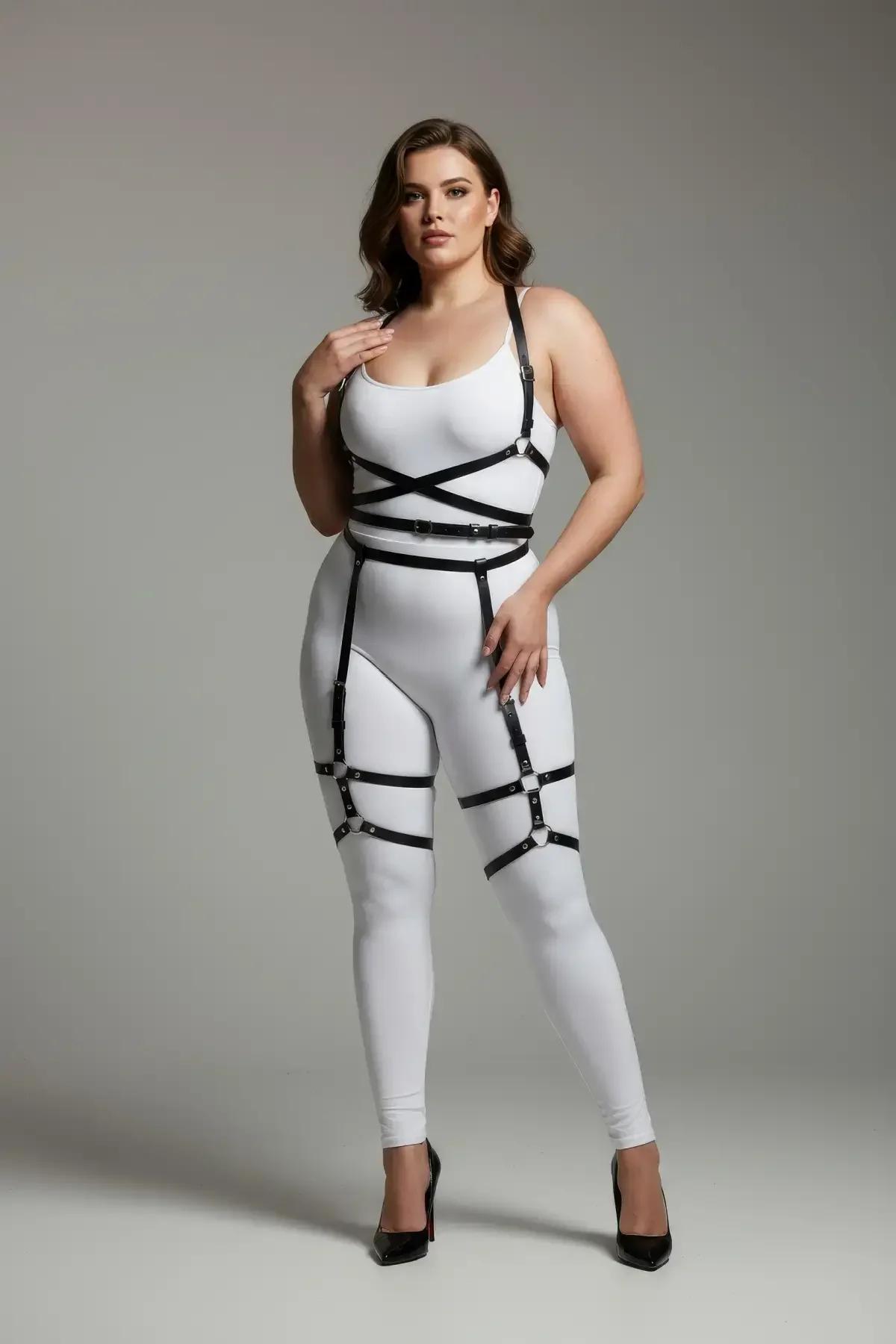 Black faux leather full body harness with X-cross chest straps, four-buckle waist band, and garter thigh cuffs worn over whit