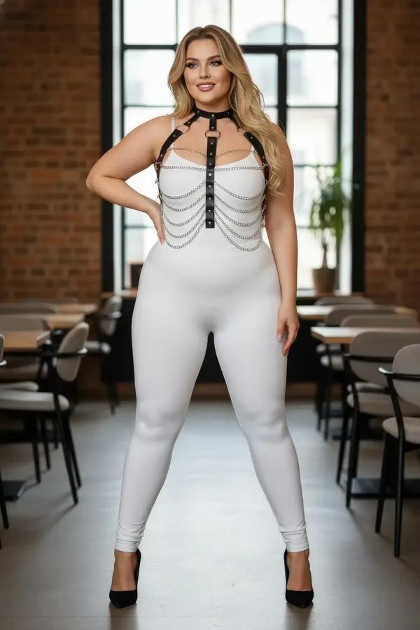 black faux leather body harness with layered silver chains and stud hardware worn over white bodysuit