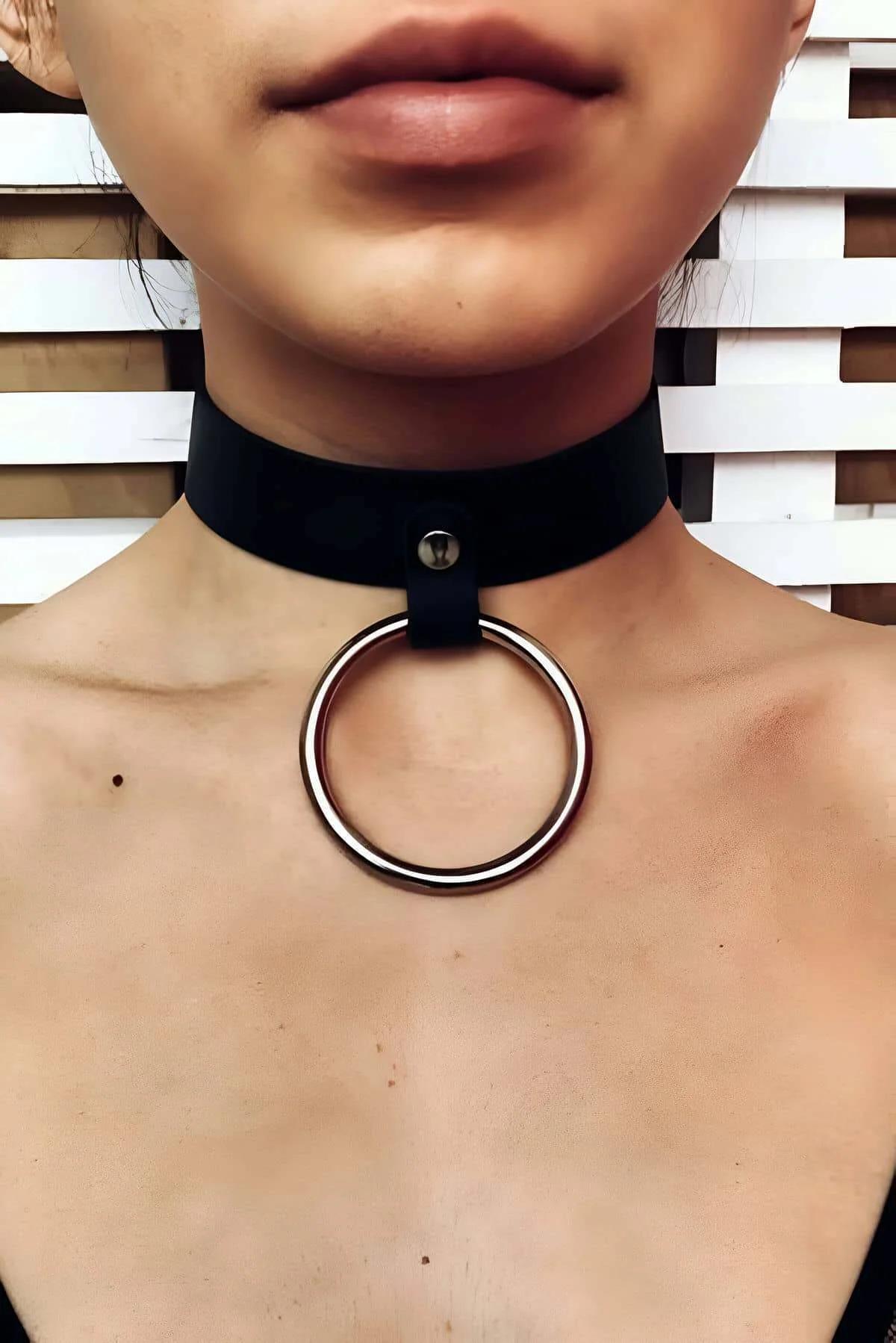 Black wide-band faux leather O-ring choker collar with gold-tone metal ring pendant on model