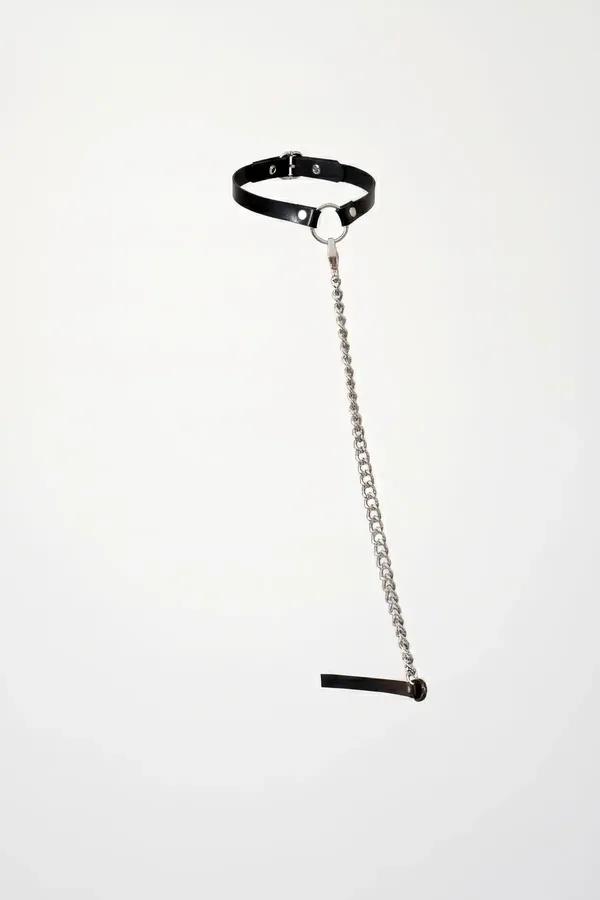 Black faux leather choker with silver O-ring and long detachable silver curb chain drop on white background