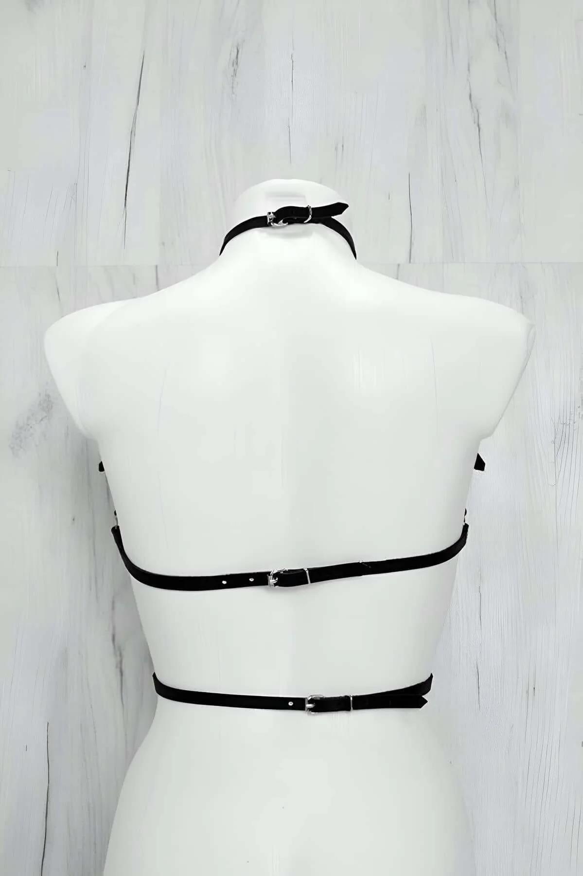 side view of black strappy chest harness showing silver slide buckle adjusters