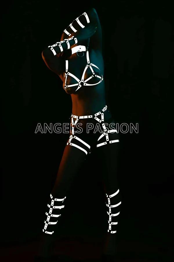 White reflective full body harness set with silver O-ring chest cage, waist belt, thigh cuffs, and arm bands glowing under da