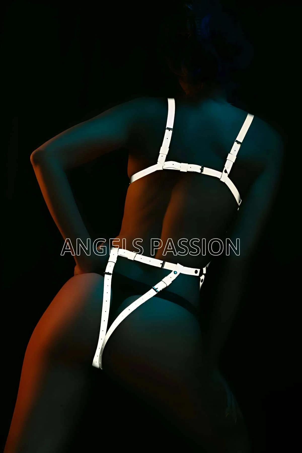 Geometric cage harness glowing bright white under direct strobe lighting against black background