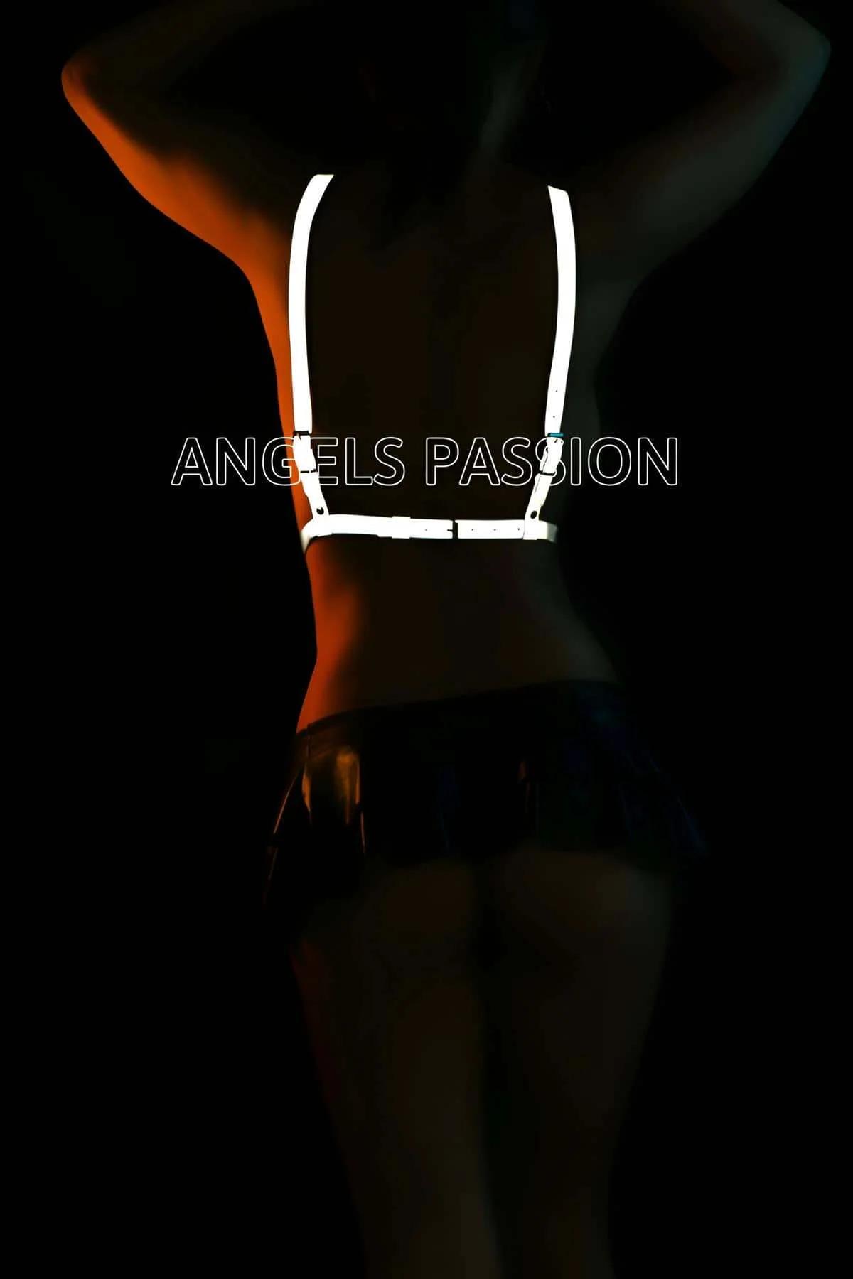 White body harness straps glowing under stage lighting showing high-visibility reflective coating effect