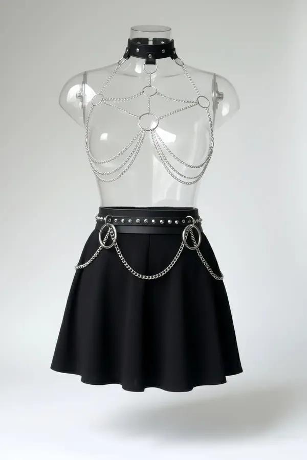 Silver chain body harness with black studded choker and waist belt, multiple O-rings and layered curb-link chains on mannequi