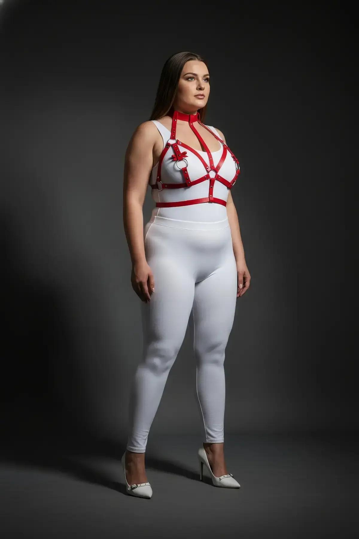 Red strappy harness layered over white bodysuit showing adjustable underbust band with two side O-rings