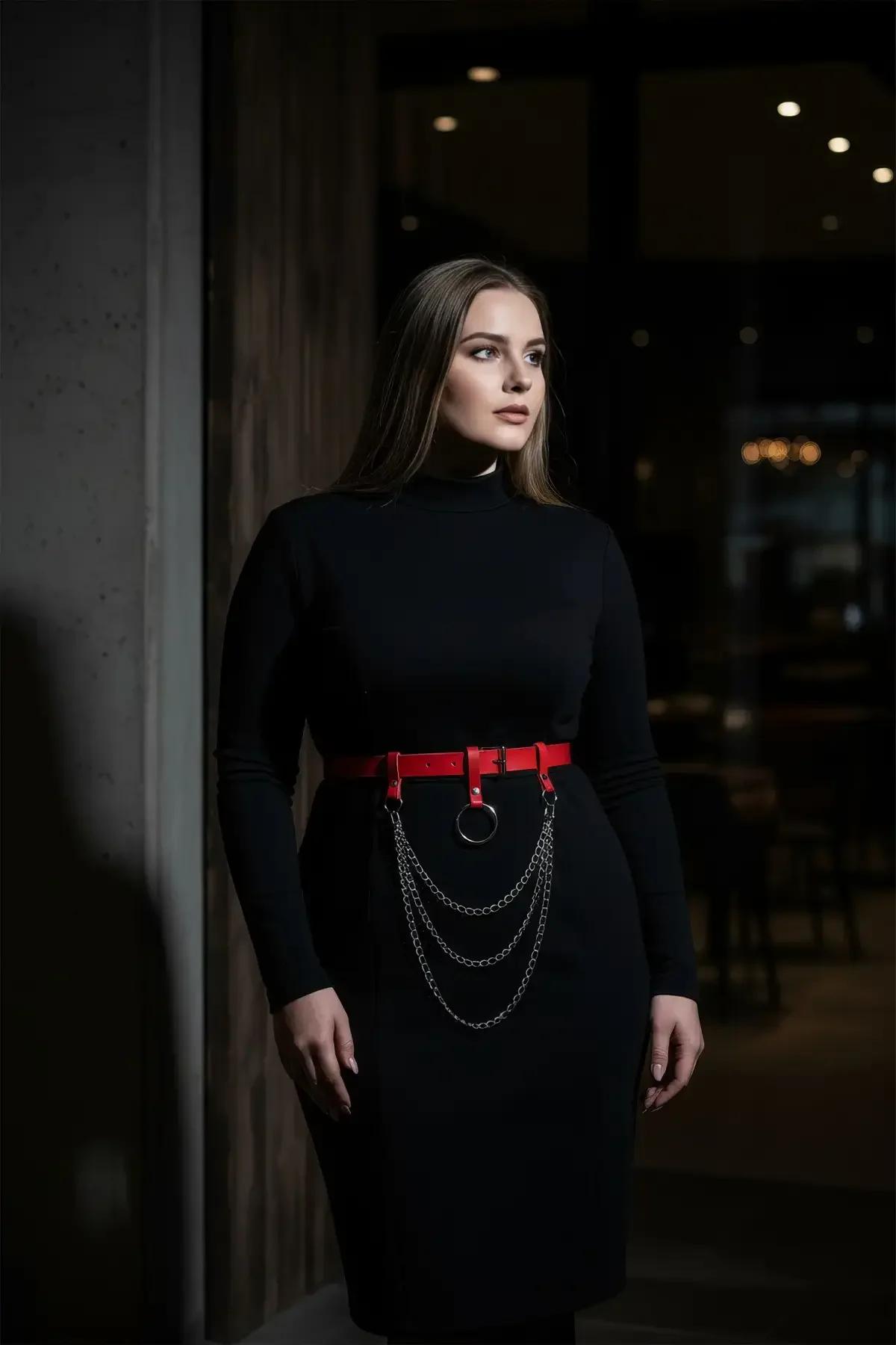 red faux leather waist harness belt with black O-ring and triple draped gunmetal chains worn over black dress