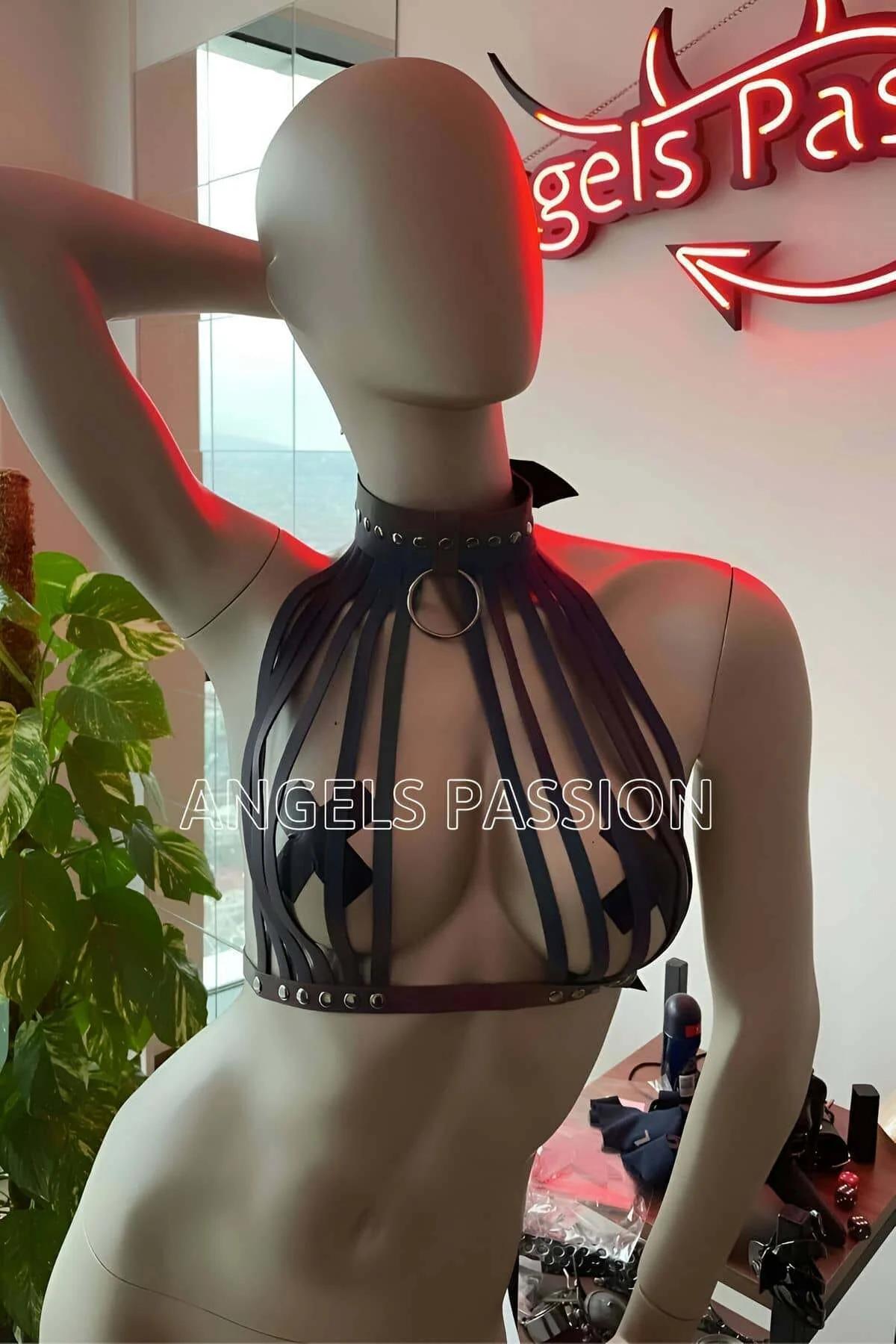 Iridescent multi-strap harness draped over black trousers showing full strap length at torso