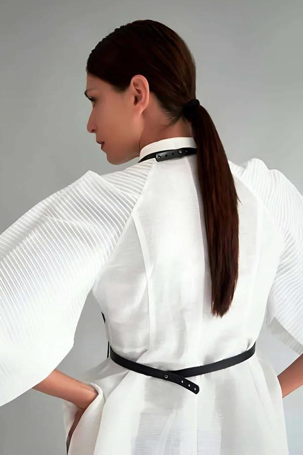 Black faux leather minimalist body harness back view showing slim collar strap waist band and vertical connector worn over wh