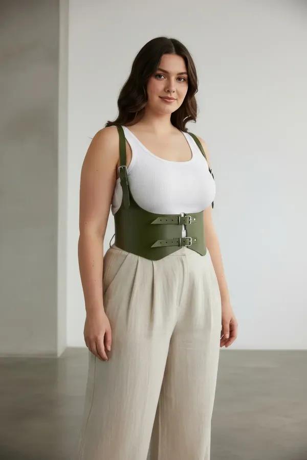 olive faux leather waist harness with double silver buckles worn over white tank top plus size model