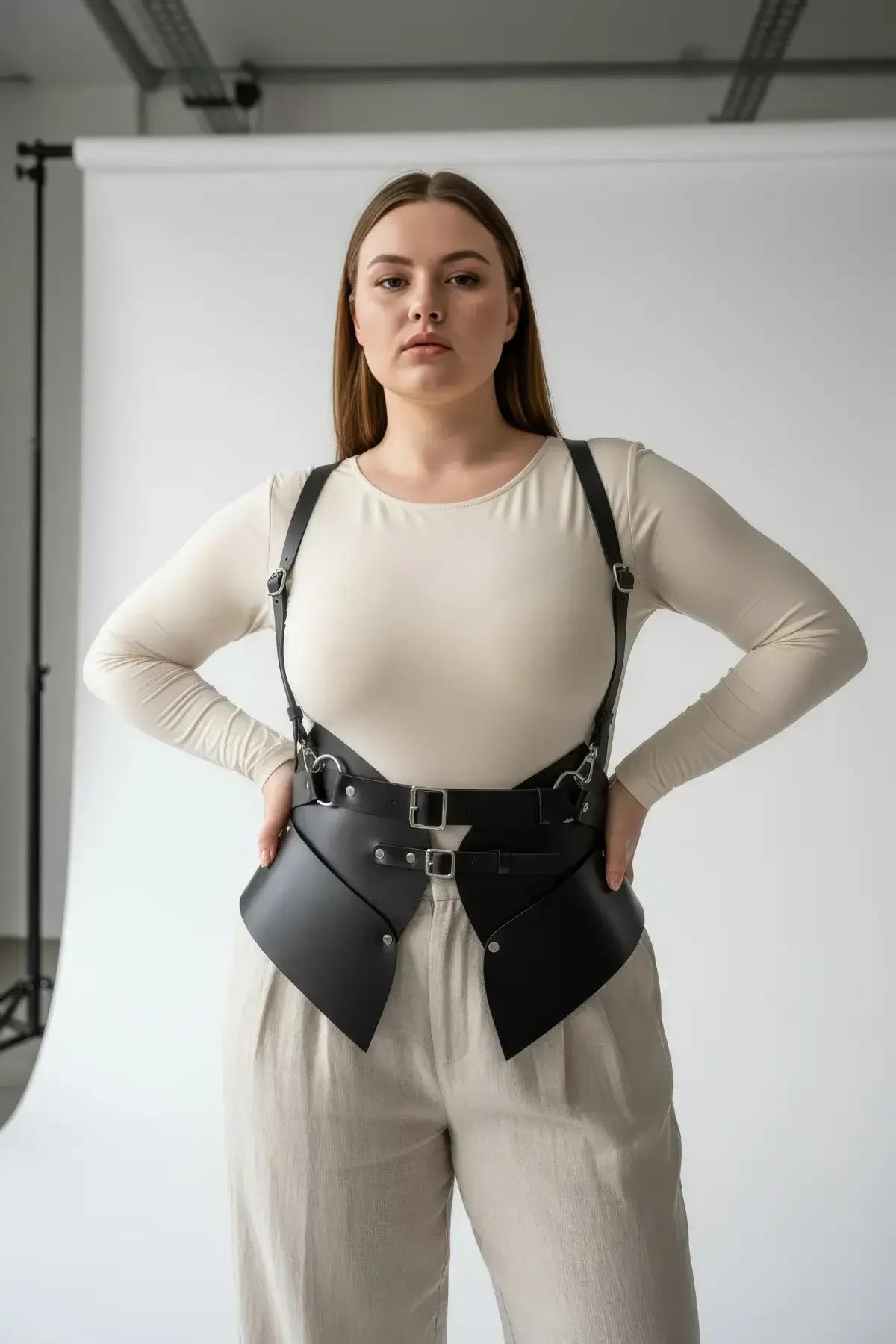 Back view of black faux leather harness belt showing adjustable strap length and panel construction