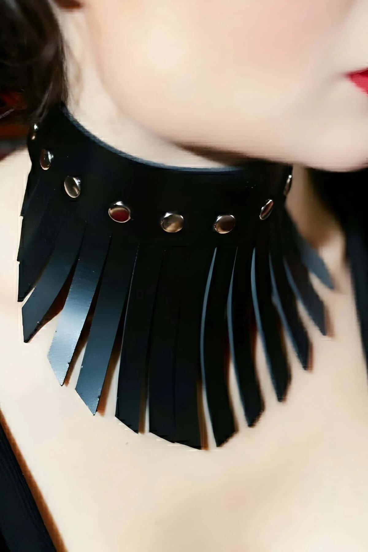 close-up of silver dome rivets on black faux leather choker band upper edge
