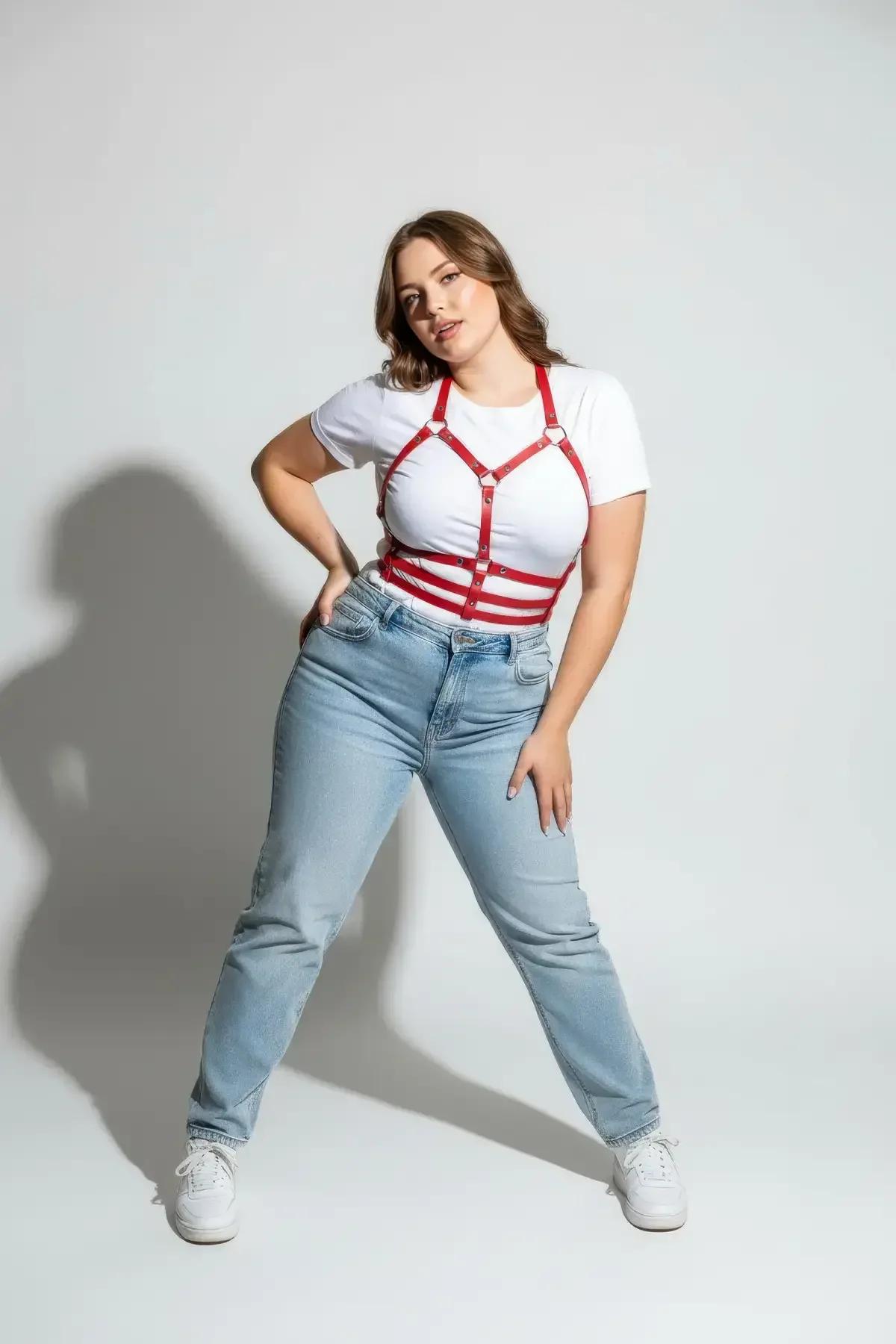 plus size model wearing red faux leather harness over white crew-neck tee and jeans