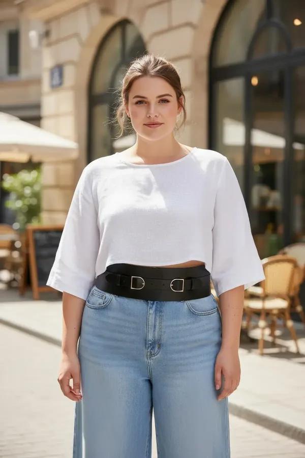 black wide faux leather waist harness belt with two silver D-ring buckles worn over white crop top and jeans