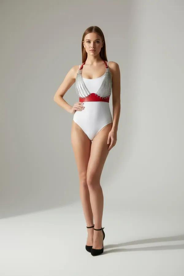 Red faux leather body harness with cascading silver chains and studded underbust band worn over white bodysuit