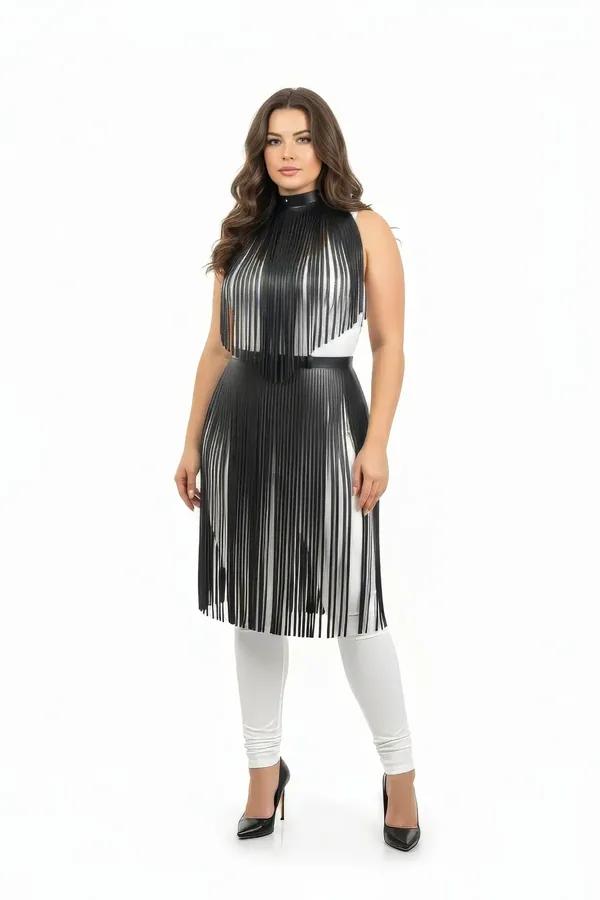 Black vegan leather fringe overlay high neck harness dress with fitted waist band, midi length, worn over white leggings