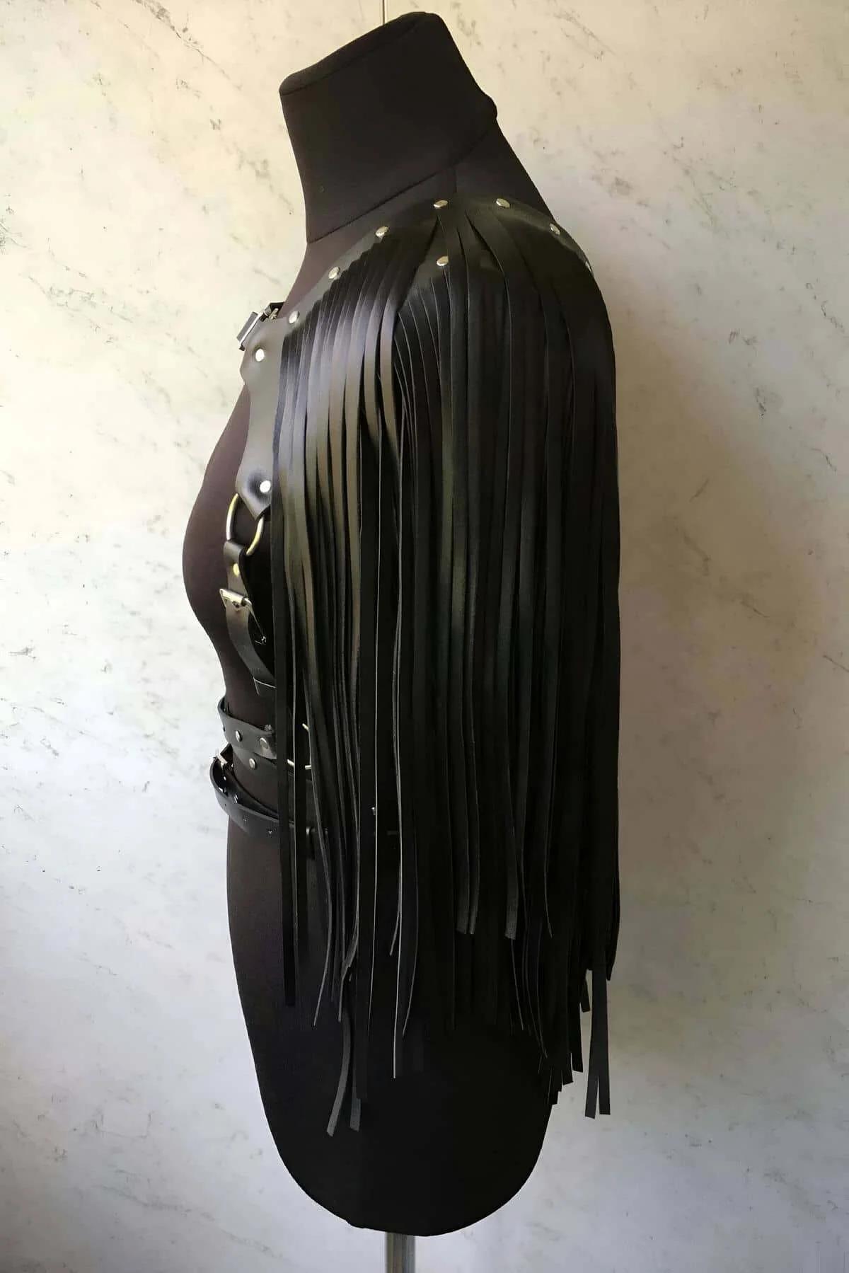 close-up of black faux leather shoulder fringe panel with silver buckle detail