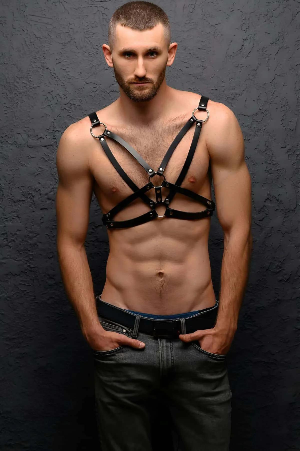 black faux leather chest harness with three silver O-rings and X-cross strap configuration on male model