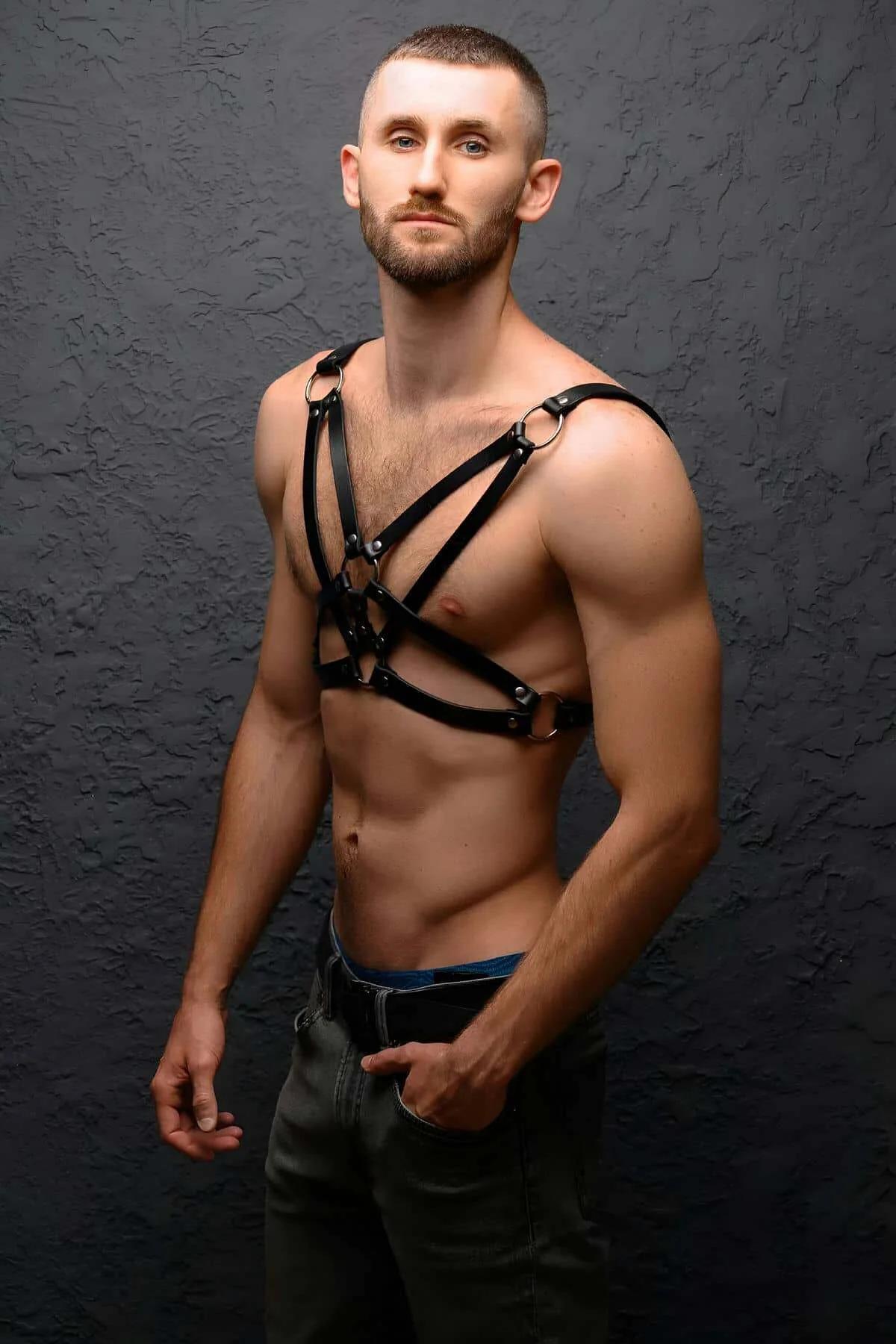 front view of black vegan leather body cage harness showing X-cross strap layout and horizontal lower straps