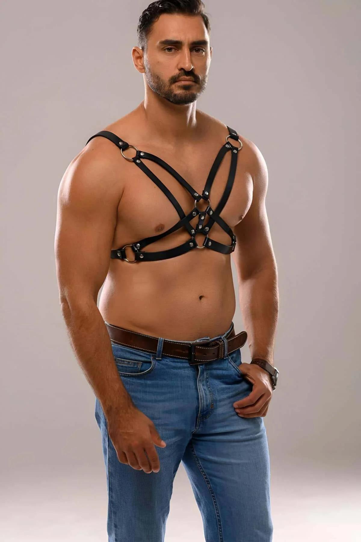 Side view of black faux leather men's chest harness showing underarm strap loop and shoulder crossing
