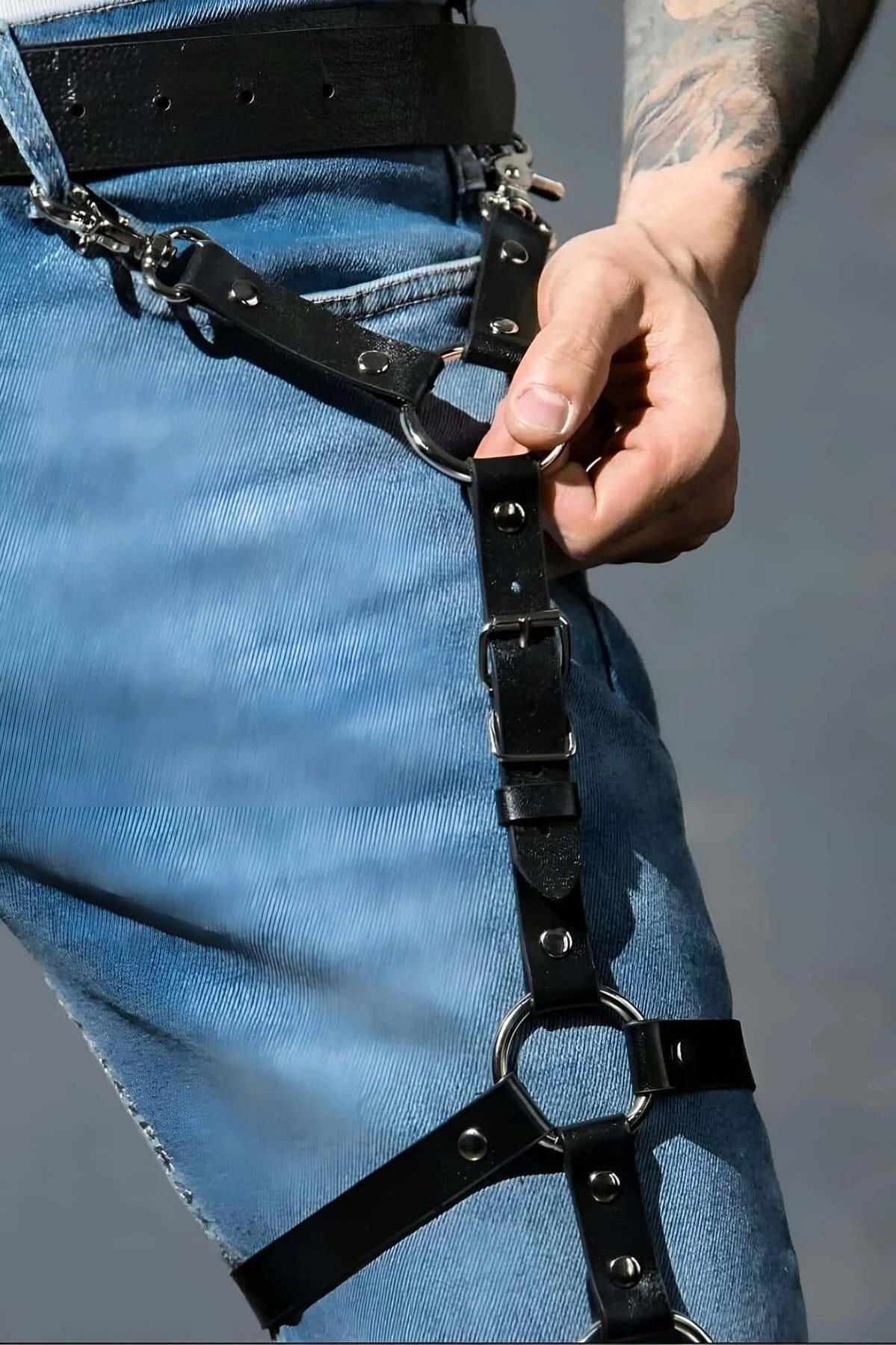 close-up of gunmetal O-ring and roller-bar buckle on black faux leather thigh harness strap